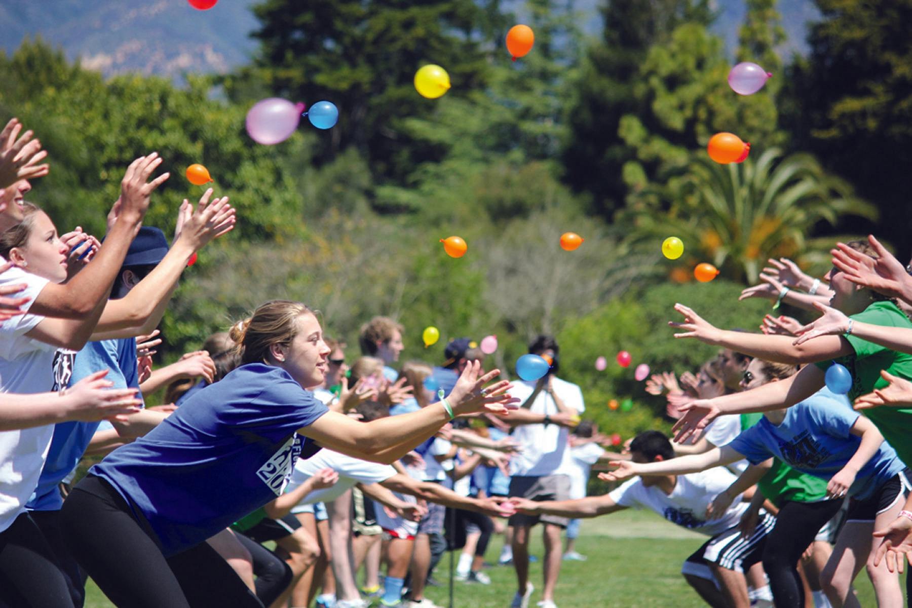 A field day which teams are tossing water balloons back and forth 