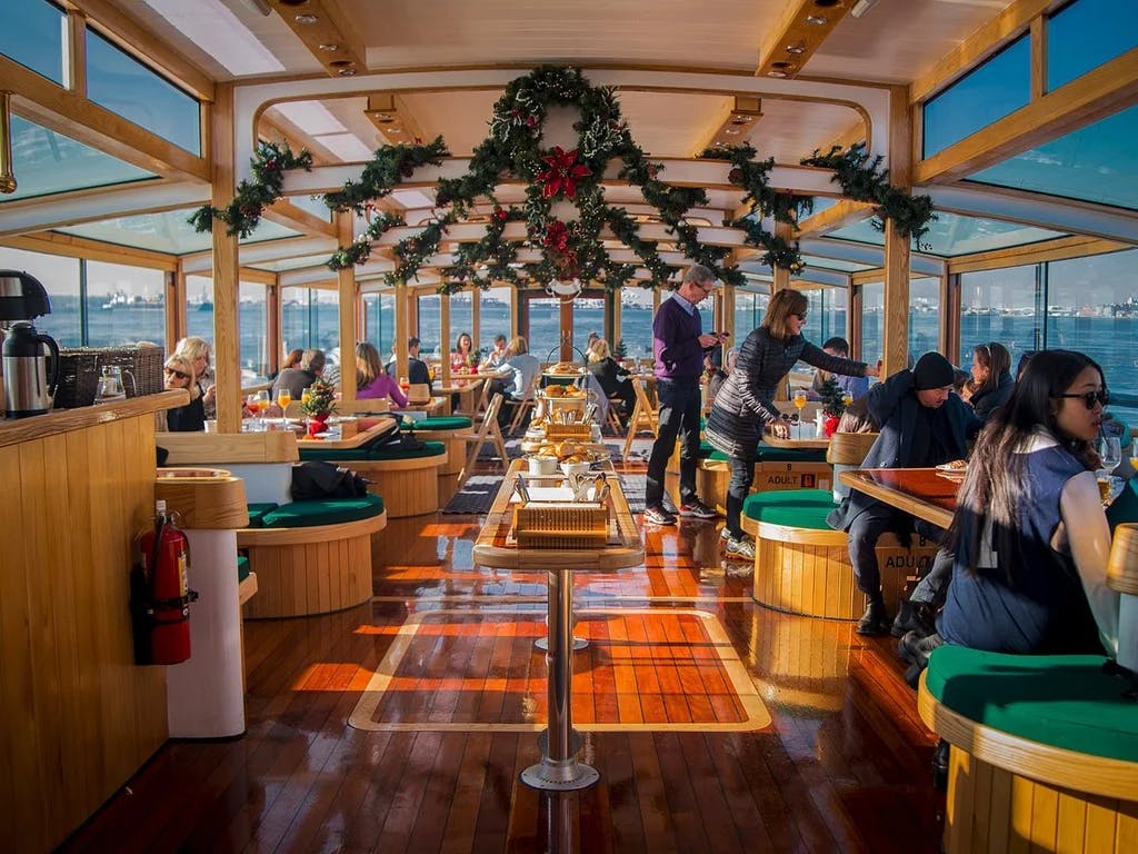 an inside of a yacht with table, chairs, and glass windows all around