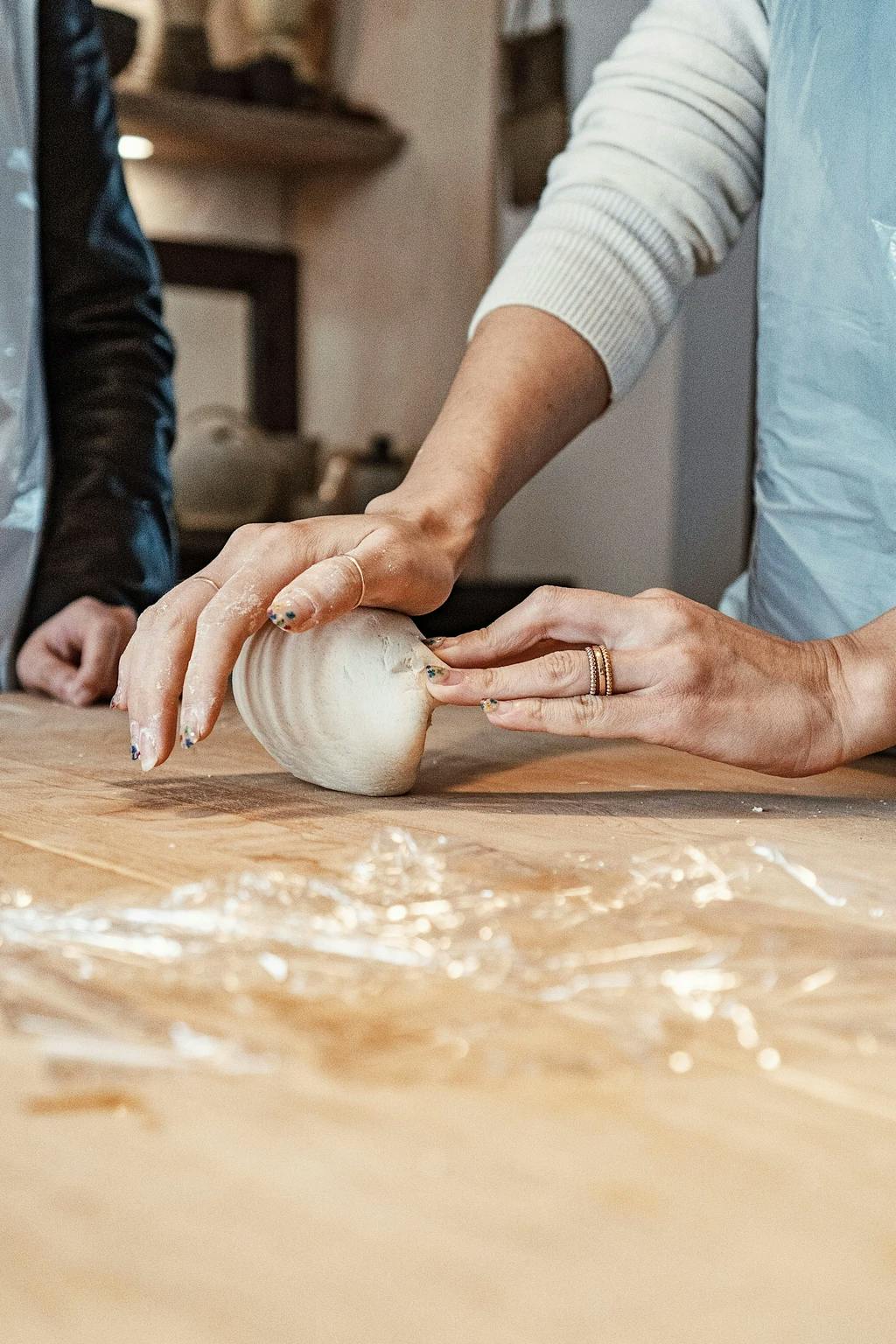 a close up of someone hand rolling dough