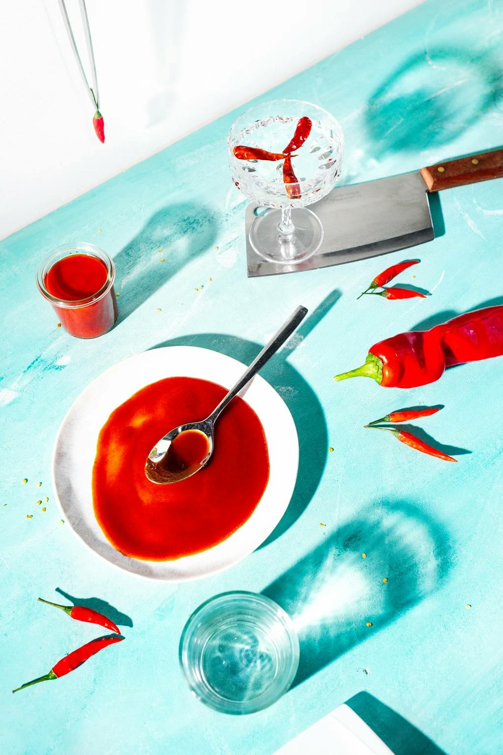a table with hot suace ingredients and a bowl of hot sauce