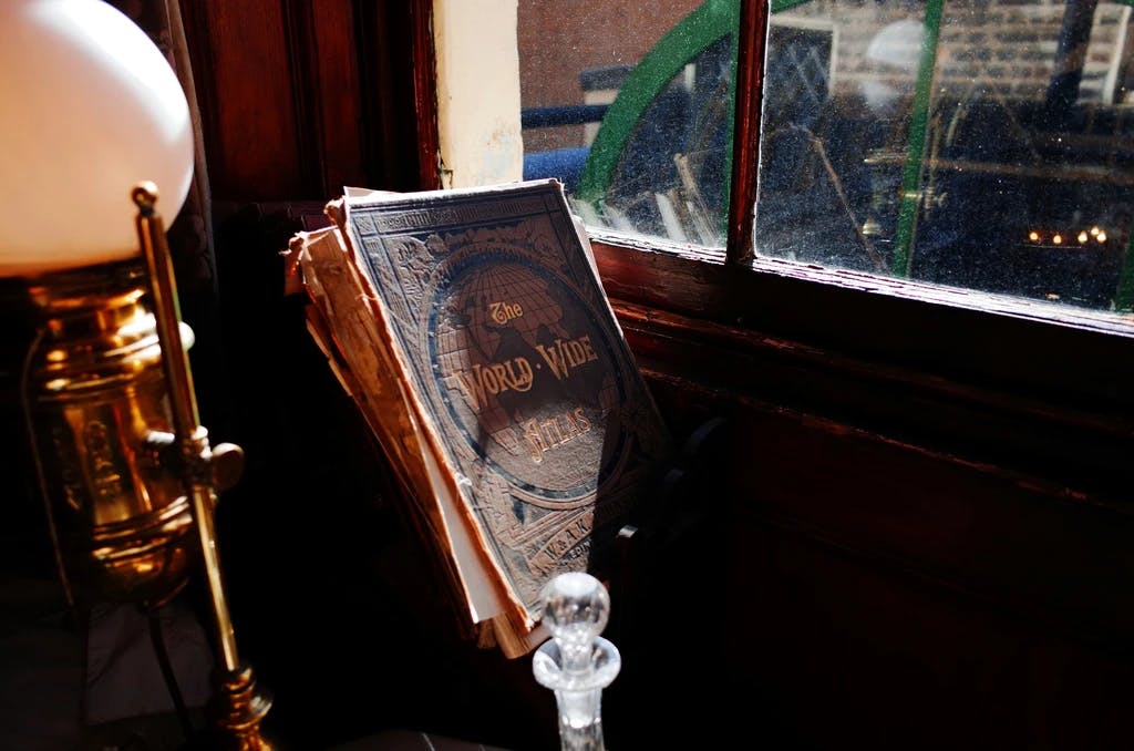an old book on a stand infront of a window