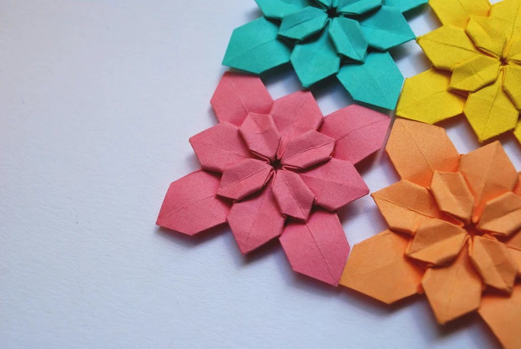 a close up of different colored origami flowers