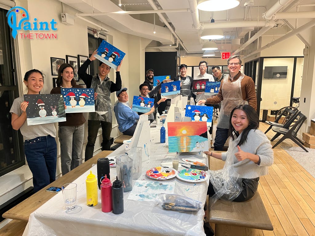 people holding up the paintings they made and smiling