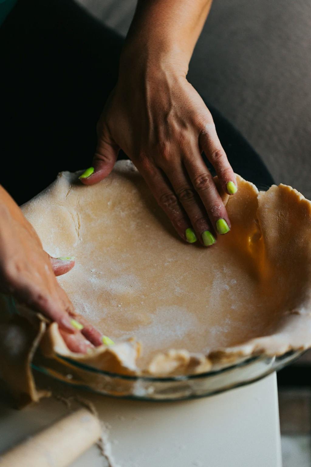 somone molding a pie crust into a dish