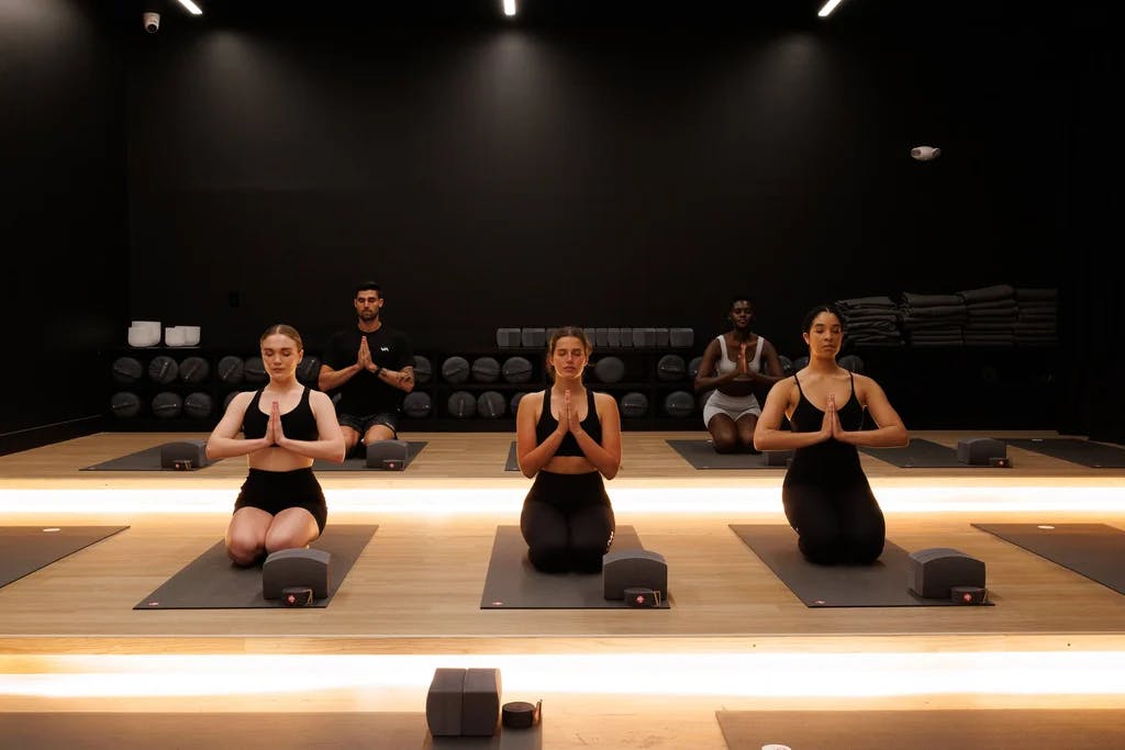 a group of women sitting in a yoga studio