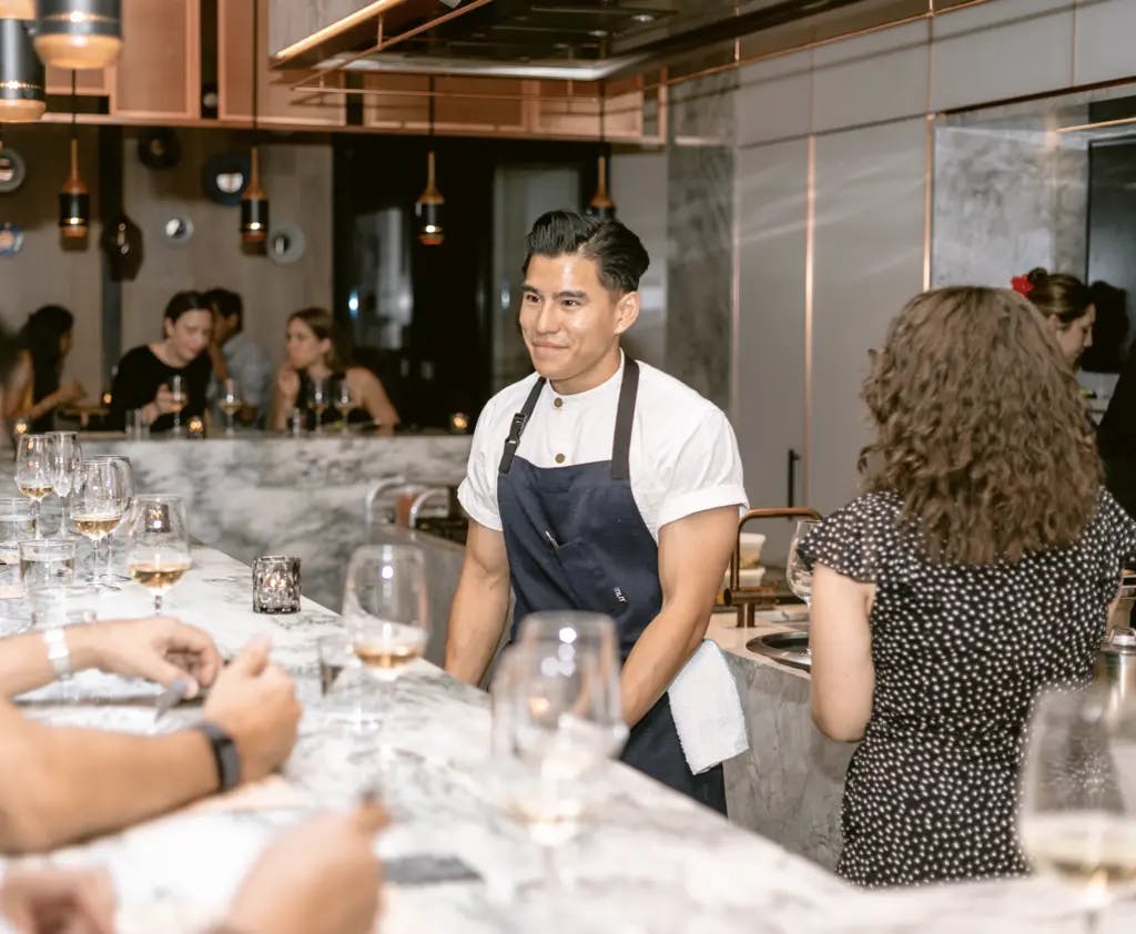 a chef standing at a table infront of people