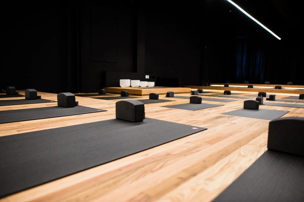 an open yoga studio with yoga mats and yoga blocks set up