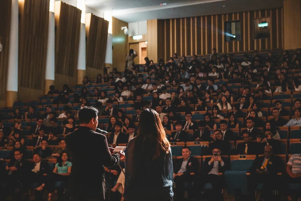 two speakers standing infront of a large crowd