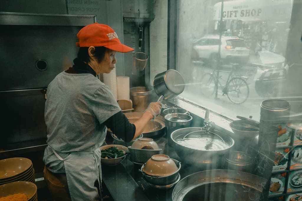 someone cooking in a window in chinatown
