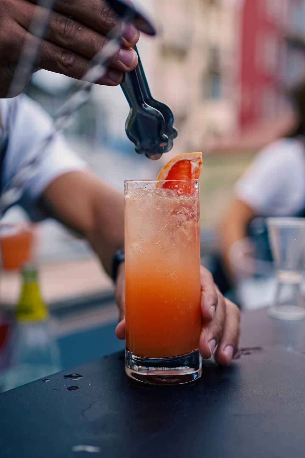 somone making a drink with blood organe and ice in it