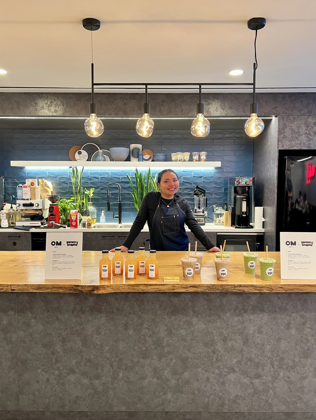 a women standing behing a juice bar