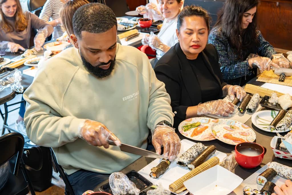 a close up of someone hand rolling a sushi roll
